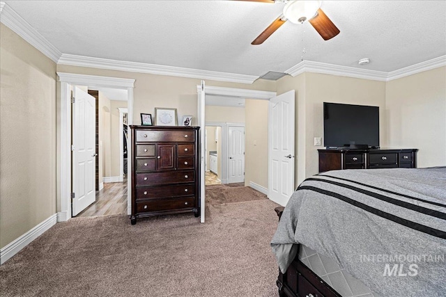 carpeted bedroom featuring a textured ceiling, ornamental molding, and baseboards