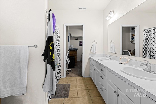 bathroom with double vanity, tile patterned flooring, and a sink