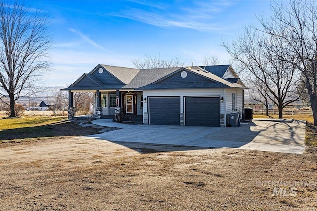 ranch-style home with a garage, covered porch, central AC, and driveway