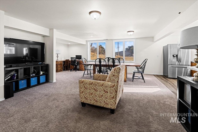 carpeted living area featuring baseboards