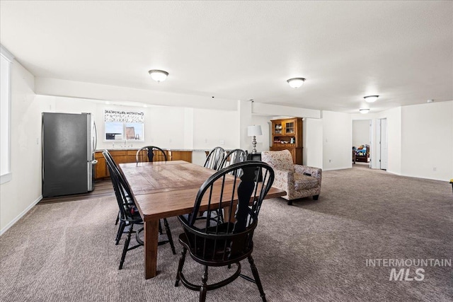 dining area featuring carpet flooring and baseboards