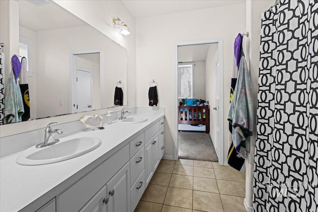 bathroom with double vanity, ensuite bath, tile patterned flooring, and a sink