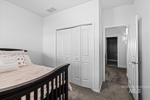 bedroom featuring baseboards, visible vents, dark colored carpet, and a closet