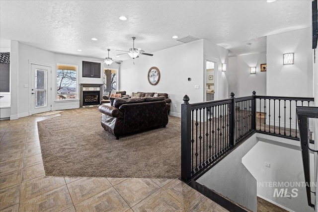 tiled living room featuring recessed lighting, a fireplace, a textured ceiling, and baseboards