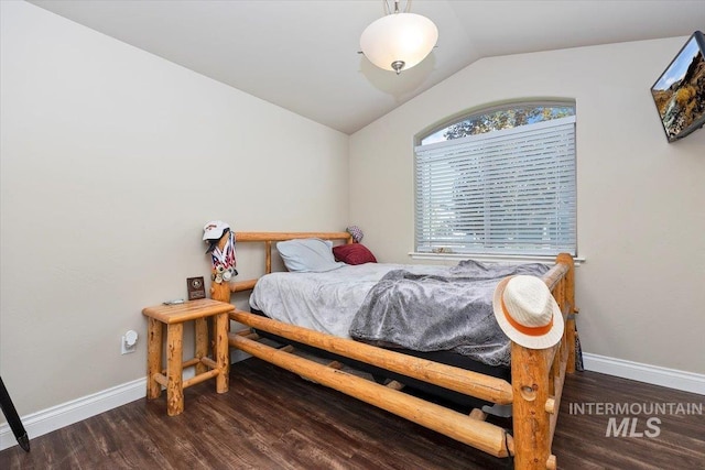 bedroom featuring wood finished floors, baseboards, and vaulted ceiling