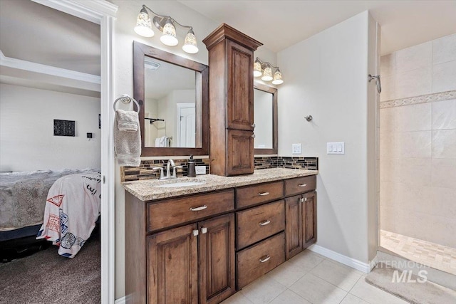 bathroom featuring a tile shower, backsplash, ensuite bathroom, and tile patterned flooring