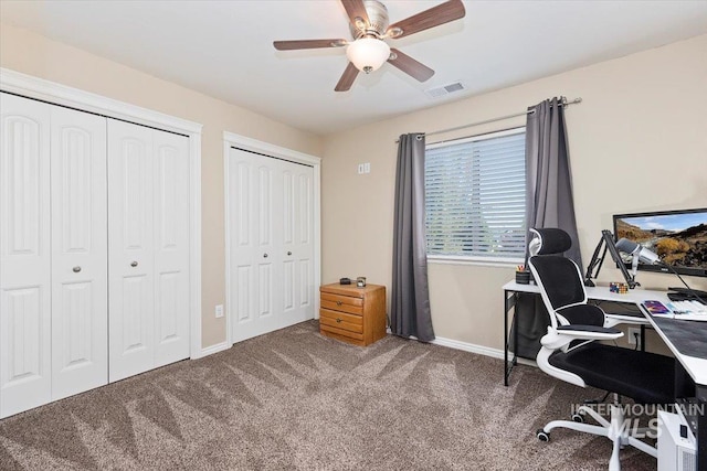 carpeted office featuring a ceiling fan, baseboards, and visible vents