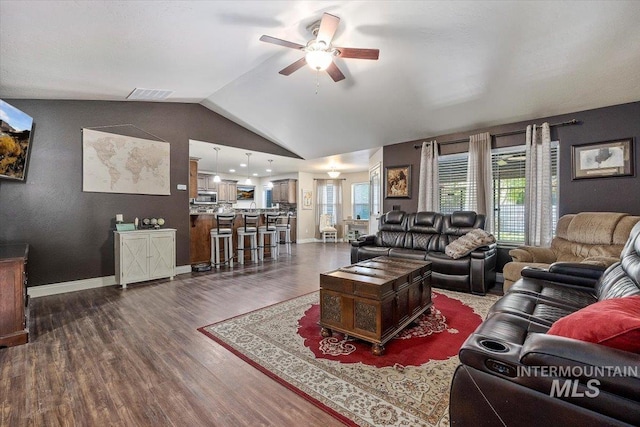 living area featuring visible vents, baseboards, ceiling fan, vaulted ceiling, and dark wood-style floors