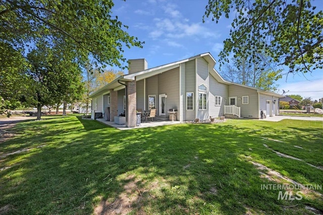 34 S 150 E, Burley, ID 83318 - rear view of property with an attached garage, a chimney, a lawn, and a patio area