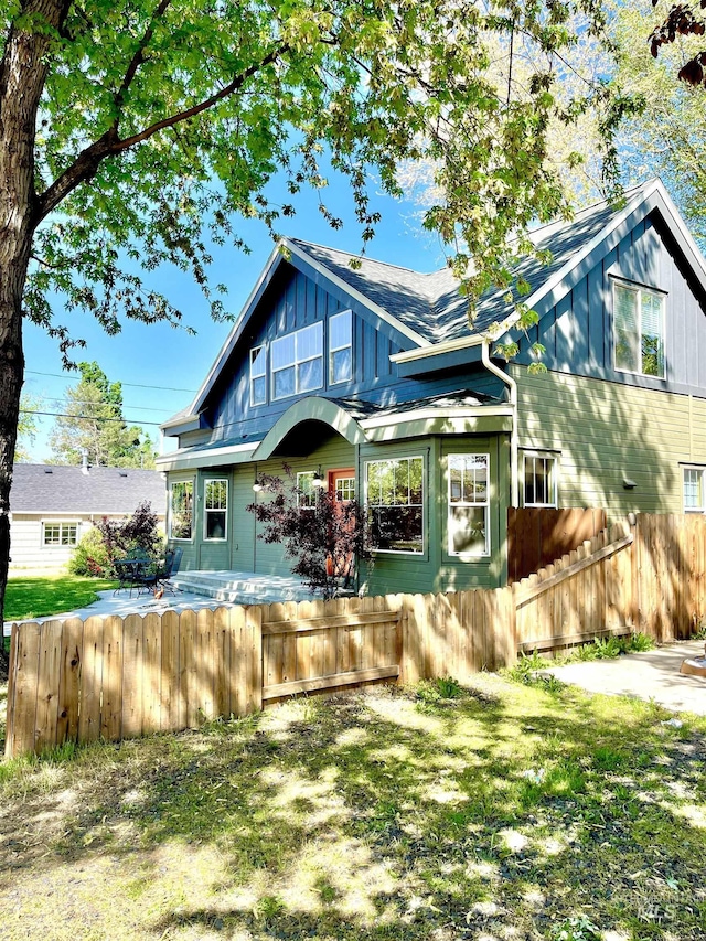 view of front of home with fence and board and batten siding