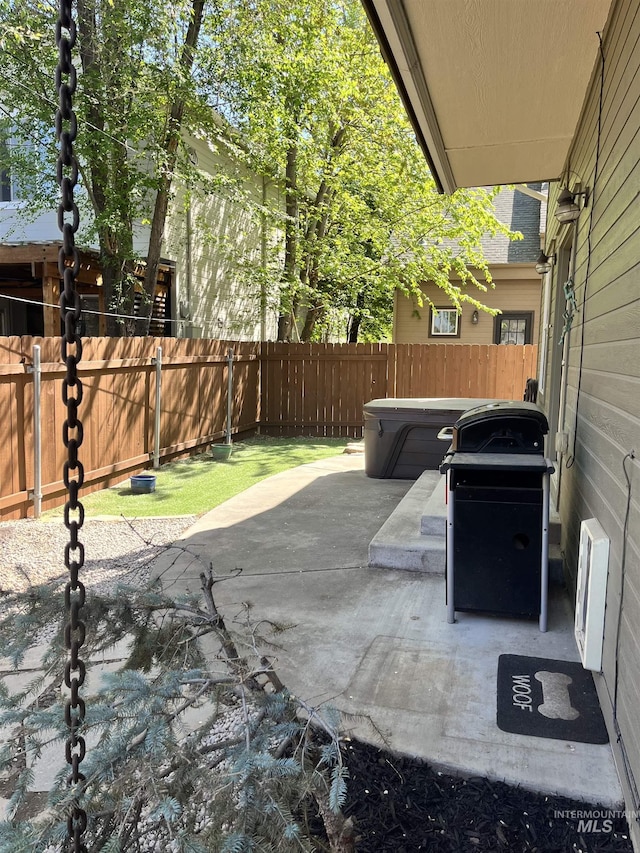 view of patio featuring area for grilling, a hot tub, and a fenced backyard