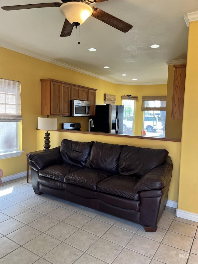 living area featuring light tile patterned flooring, a ceiling fan, baseboards, crown molding, and recessed lighting