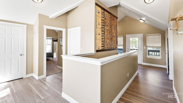 corridor featuring vaulted ceiling, wood finished floors, and baseboards