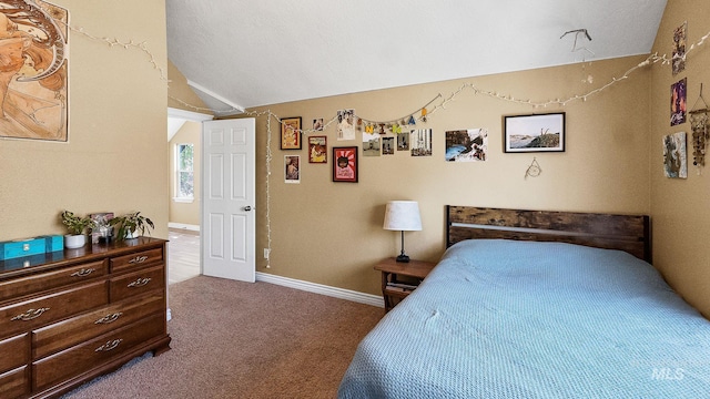 bedroom with carpet floors, lofted ceiling, and baseboards
