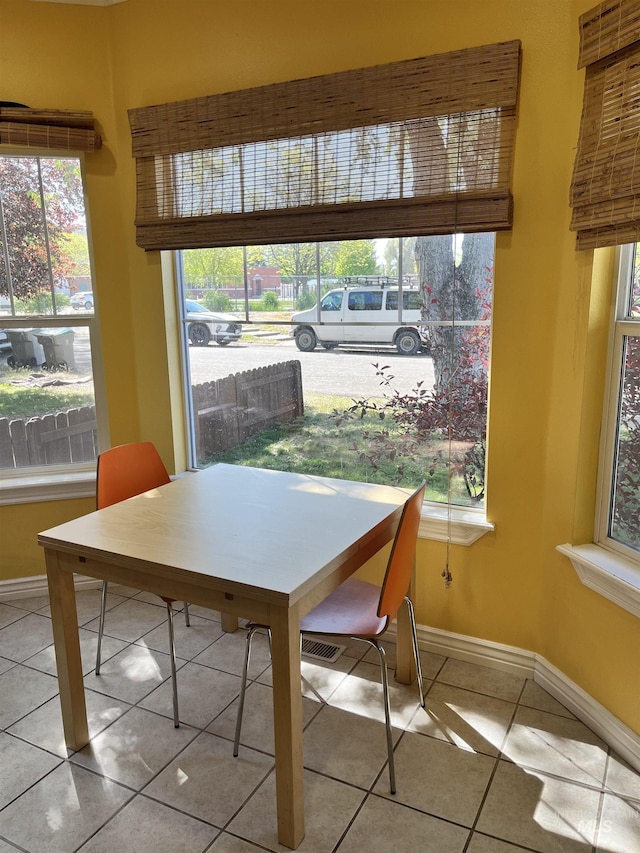 tiled dining room with baseboards and plenty of natural light