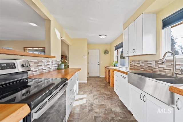 kitchen with white cabinetry, sink, tasteful backsplash, butcher block countertops, and stainless steel range with electric stovetop