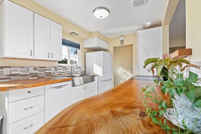 kitchen featuring backsplash, white appliances, sink, white cabinets, and butcher block countertops