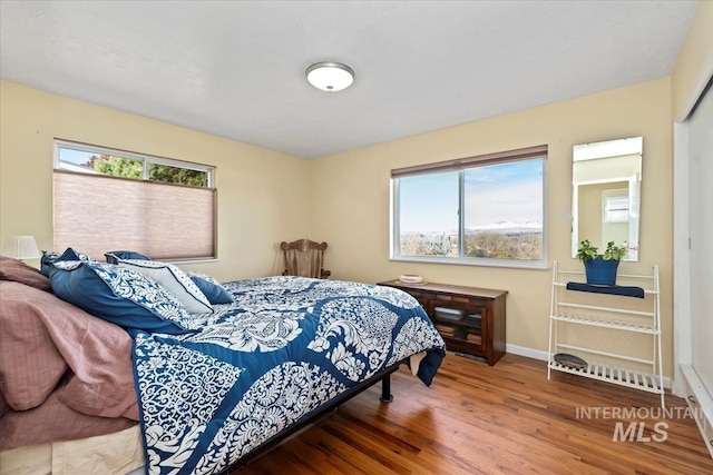 bedroom featuring hardwood / wood-style floors and multiple windows