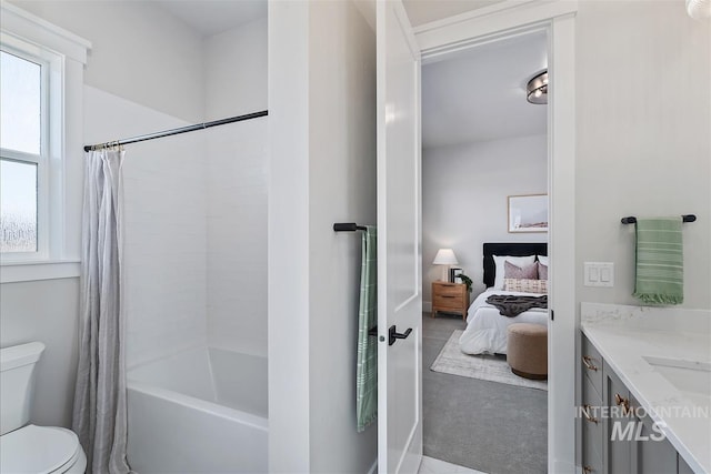 ensuite bathroom featuring vanity, plenty of natural light, connected bathroom, and toilet