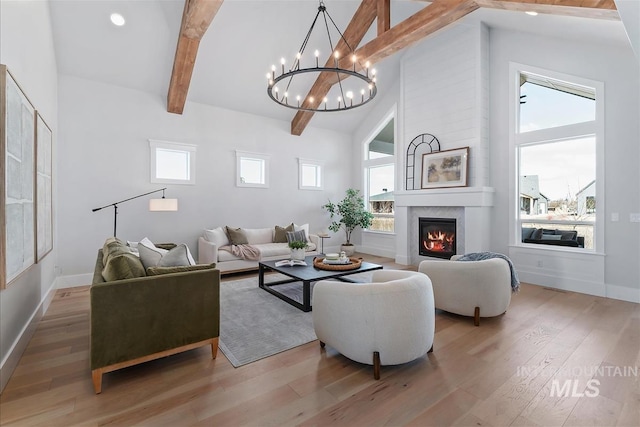 living room featuring high vaulted ceiling, a fireplace, baseboards, light wood-type flooring, and beam ceiling