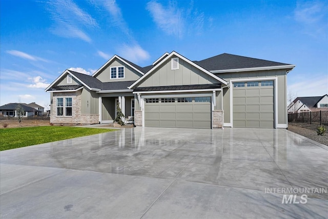 craftsman-style home featuring metal roof, a garage, board and batten siding, a front lawn, and a standing seam roof