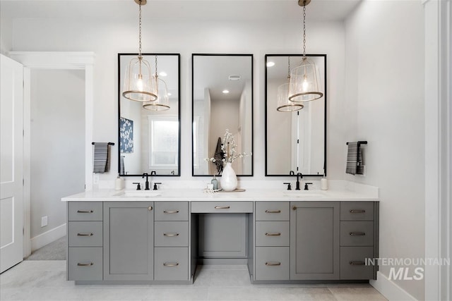 bathroom featuring double vanity, baseboards, and a sink