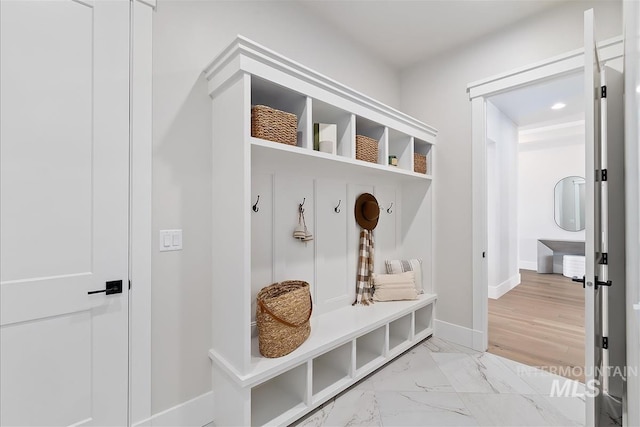 mudroom featuring marble finish floor and baseboards