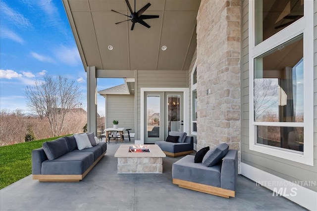 view of patio / terrace with a ceiling fan and an outdoor living space with a fire pit