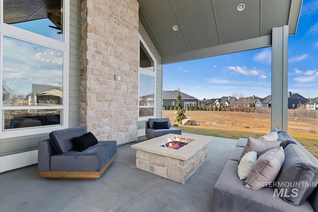 view of patio / terrace with a residential view and an outdoor living space with a fire pit