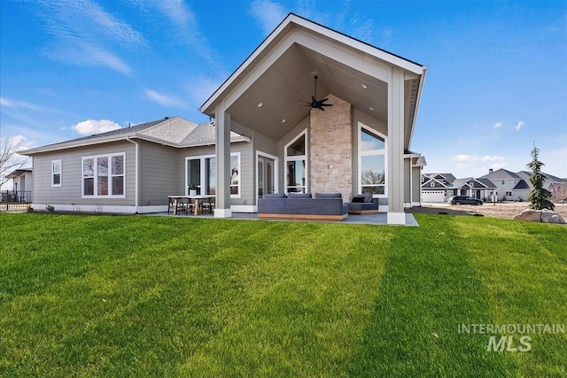 rear view of property with a patio area, ceiling fan, and a yard