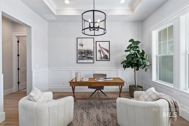 home office featuring a tray ceiling, wood finished floors, and a wealth of natural light