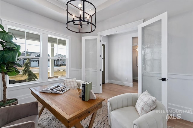 interior space with baseboards, light wood finished floors, and an inviting chandelier