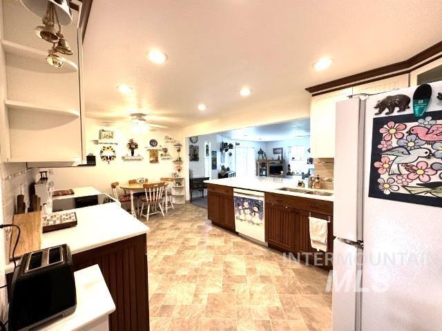 kitchen featuring ceiling fan, white appliances, dark brown cabinetry, and sink