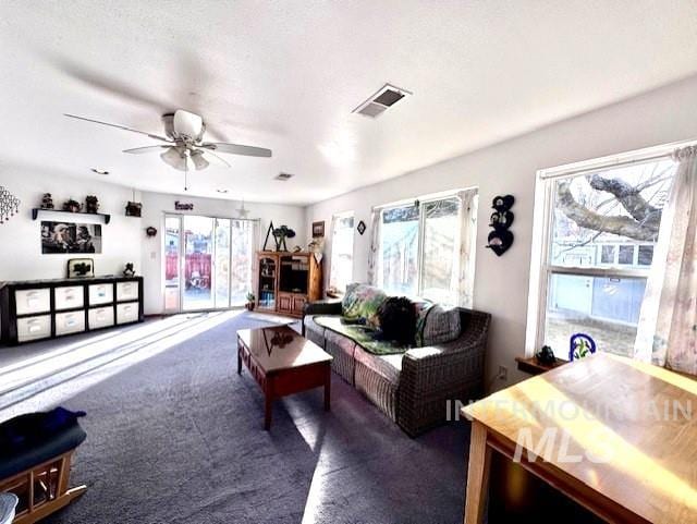 carpeted living room with ceiling fan