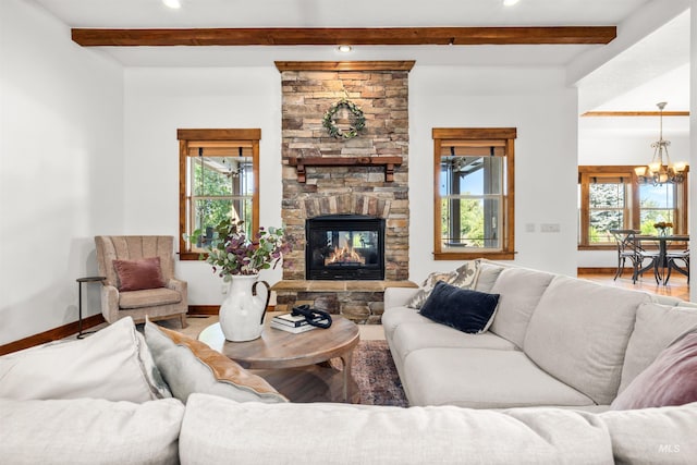 living room featuring beam ceiling, a stone fireplace, and a healthy amount of sunlight