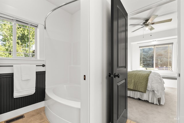 bathroom with tile patterned flooring and a tub