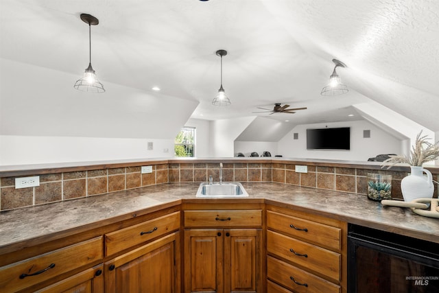 kitchen with tasteful backsplash, sink, decorative light fixtures, and vaulted ceiling