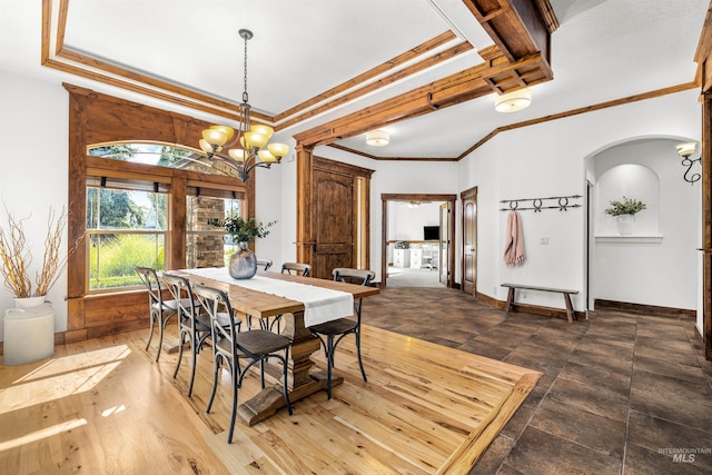 dining area with crown molding and a notable chandelier