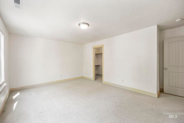 unfurnished room featuring baseboards, light colored carpet, and a smoke detector