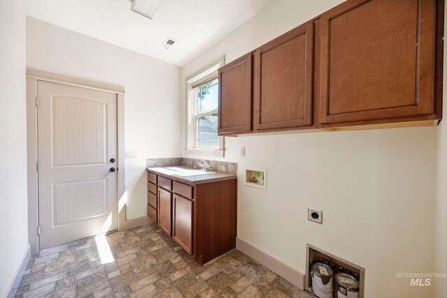 laundry area featuring electric dryer hookup, washer hookup, cabinet space, stone finish floors, and baseboards