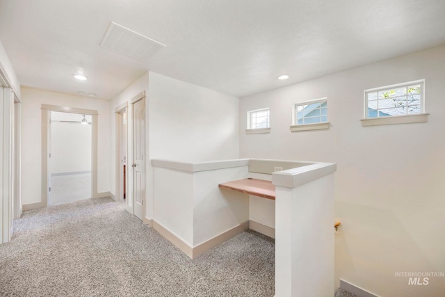 hall with baseboards, an upstairs landing, recessed lighting, and carpet flooring