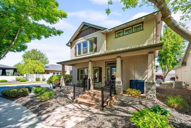 craftsman house featuring covered porch, central air condition unit, and board and batten siding