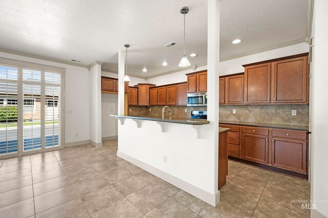 kitchen featuring stainless steel microwave, brown cabinets, tasteful backsplash, a kitchen bar, and recessed lighting