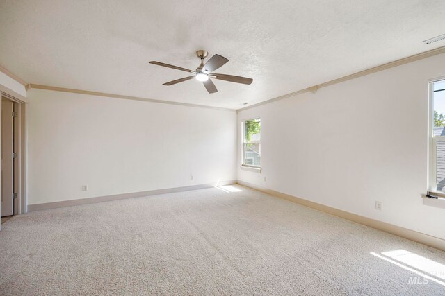 carpeted spare room featuring ornamental molding, a ceiling fan, a textured ceiling, and baseboards