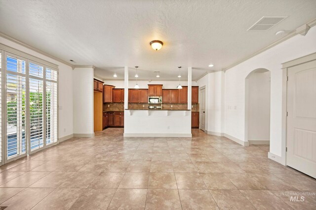 unfurnished living room with arched walkways, baseboards, a textured ceiling, light tile patterned flooring, and recessed lighting