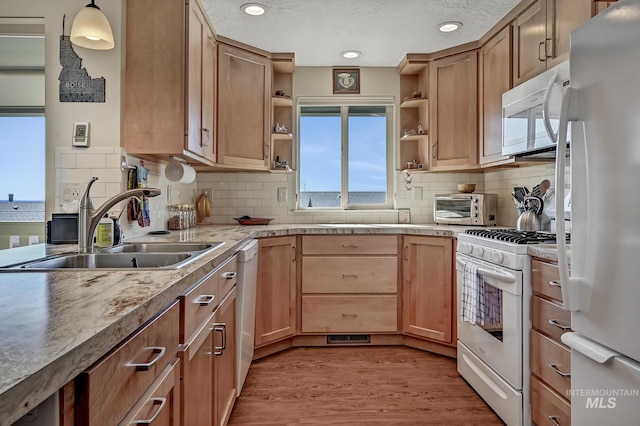 kitchen featuring white appliances, light wood finished floors, open shelves, a toaster, and a sink