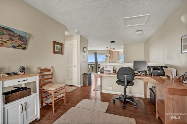 office area with attic access, baseboards, dark wood-style flooring, and a textured ceiling