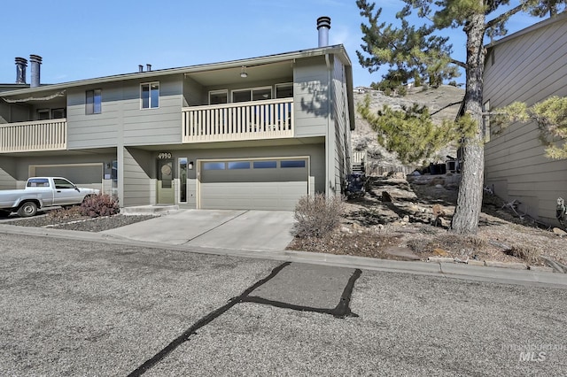 view of front of home with a garage, a balcony, and driveway