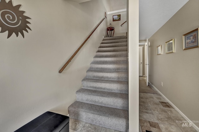 stairway with tile patterned floors and baseboards