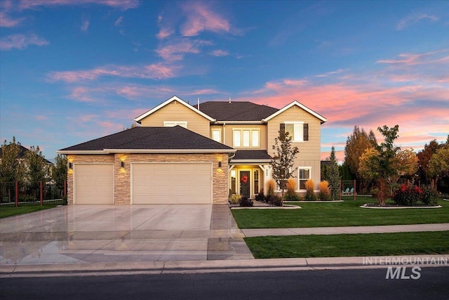 view of front of property featuring a garage and a yard